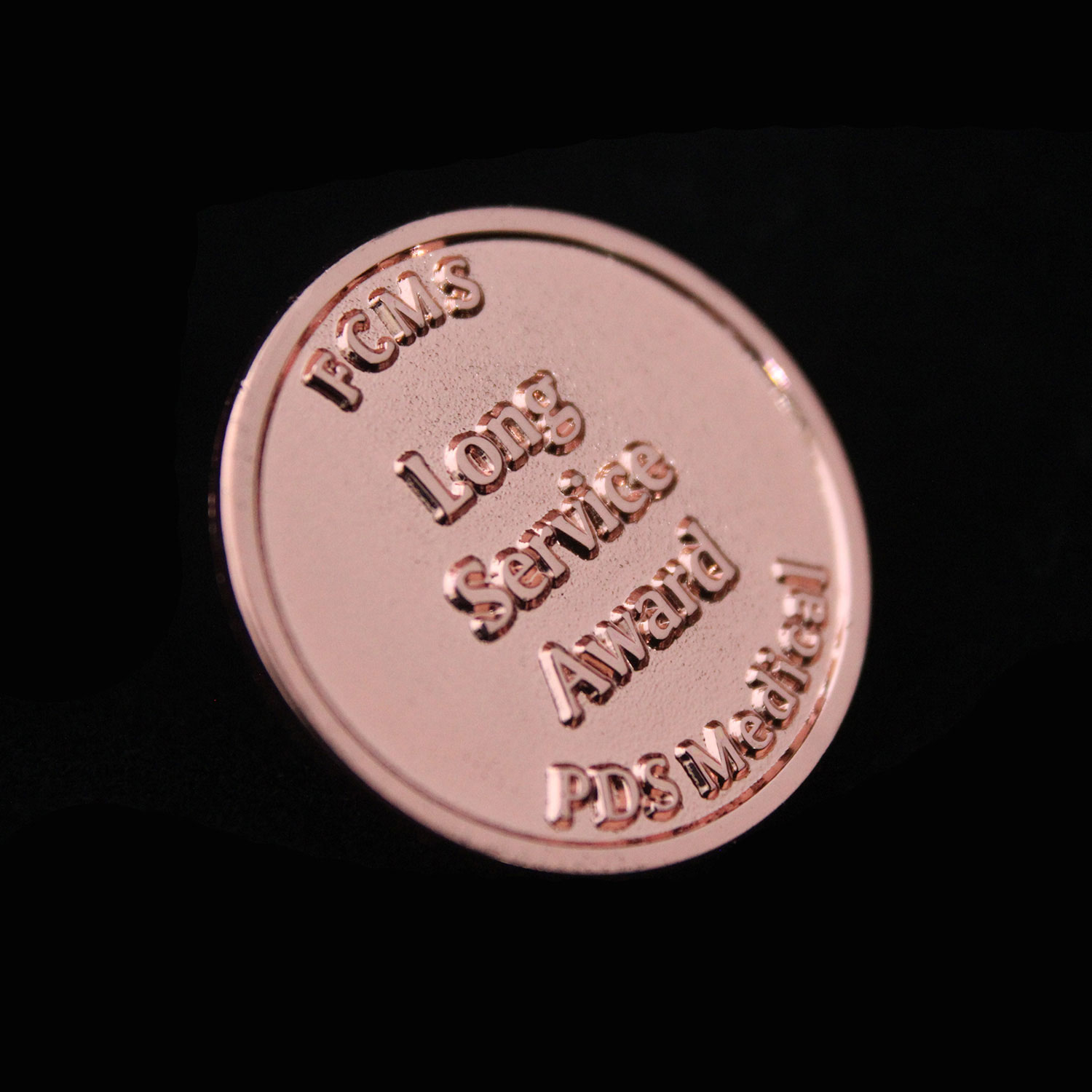 Bronze Lapel pin for FCMS PDS Medical on black background