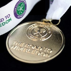 Close up of Lawn Tennis Association Road to Wimbled on Medal on black background